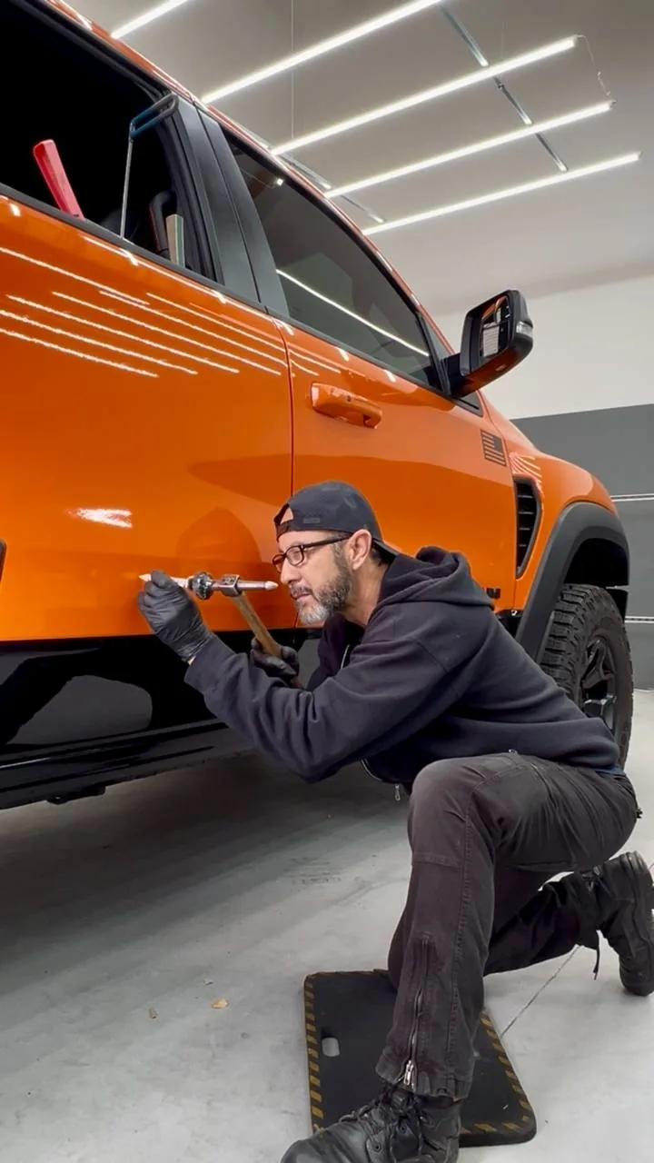 Paintless dent repair on a truck door panel in the Dent Evo Upland shop